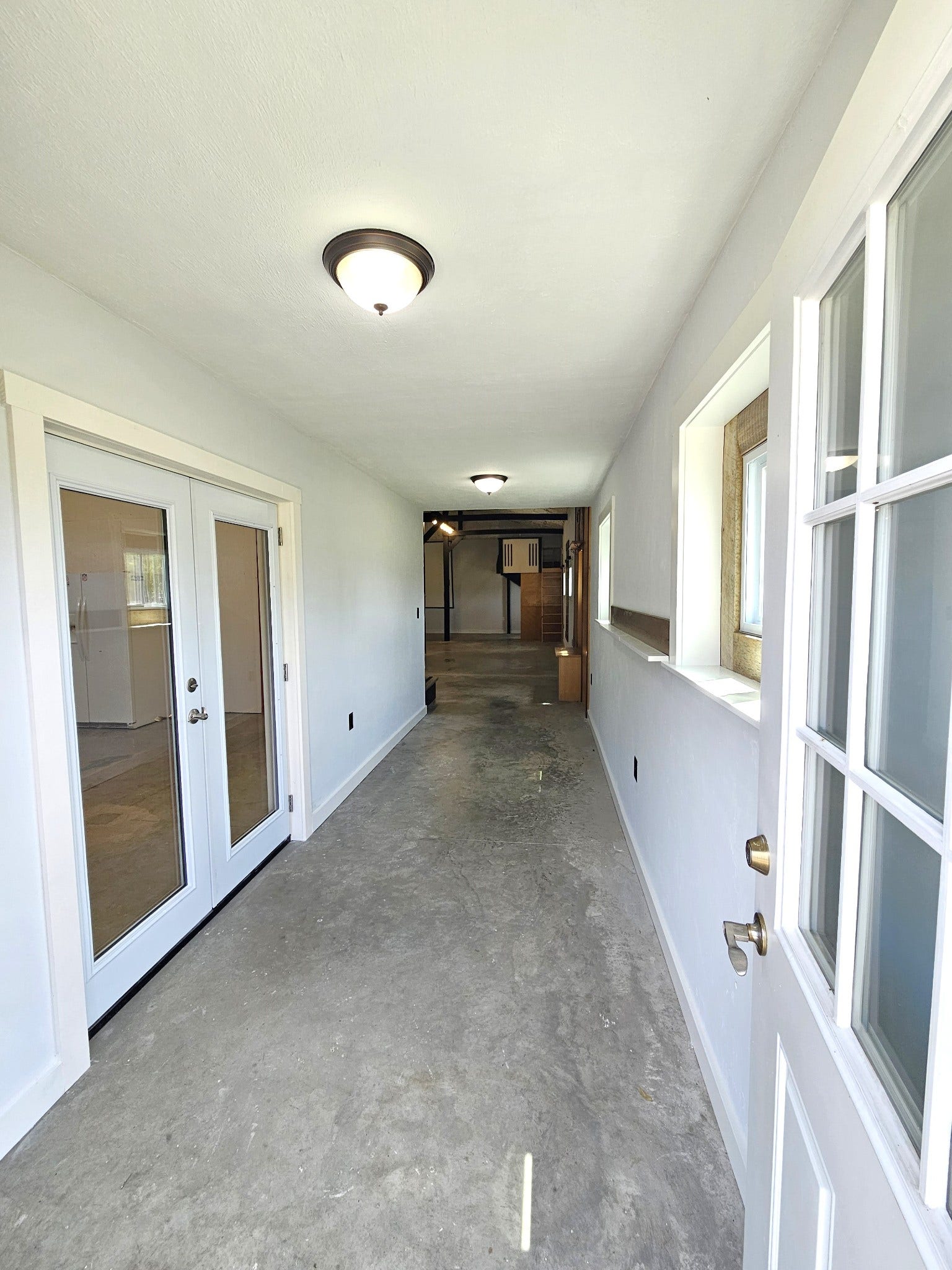 129 Highway 82 East, Bell Buckle, TN 37020 The entry foyer / hall is a great place for a side table or a bench. Concrete flooring is durable and easy to clean should you accidentally bring muddy shoes / boots in! The fire rated french doors on the left lead to the garage / workshop.