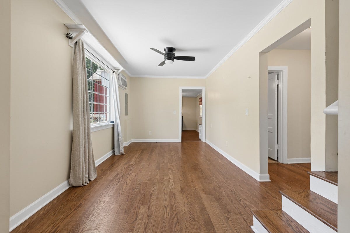 Natural sunlight pours through the large dining room window.