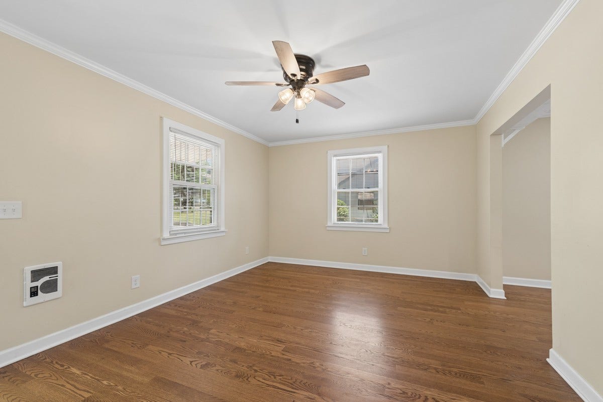 The living room features two bright windows that fill the space with natural light.