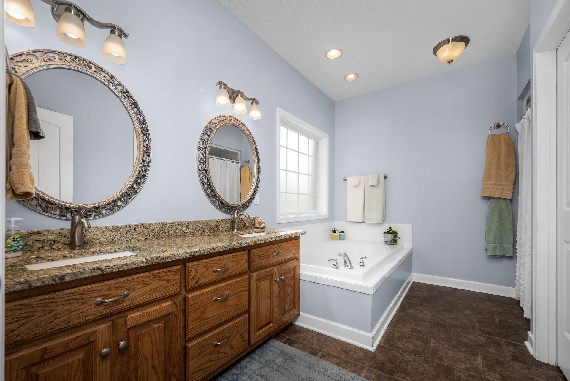 144 Richland Ct, Manchester, TN 37355 The luxurious primary bath has tile flooring, double vanity with granite countertops, water closet, separate tub and separate shower.