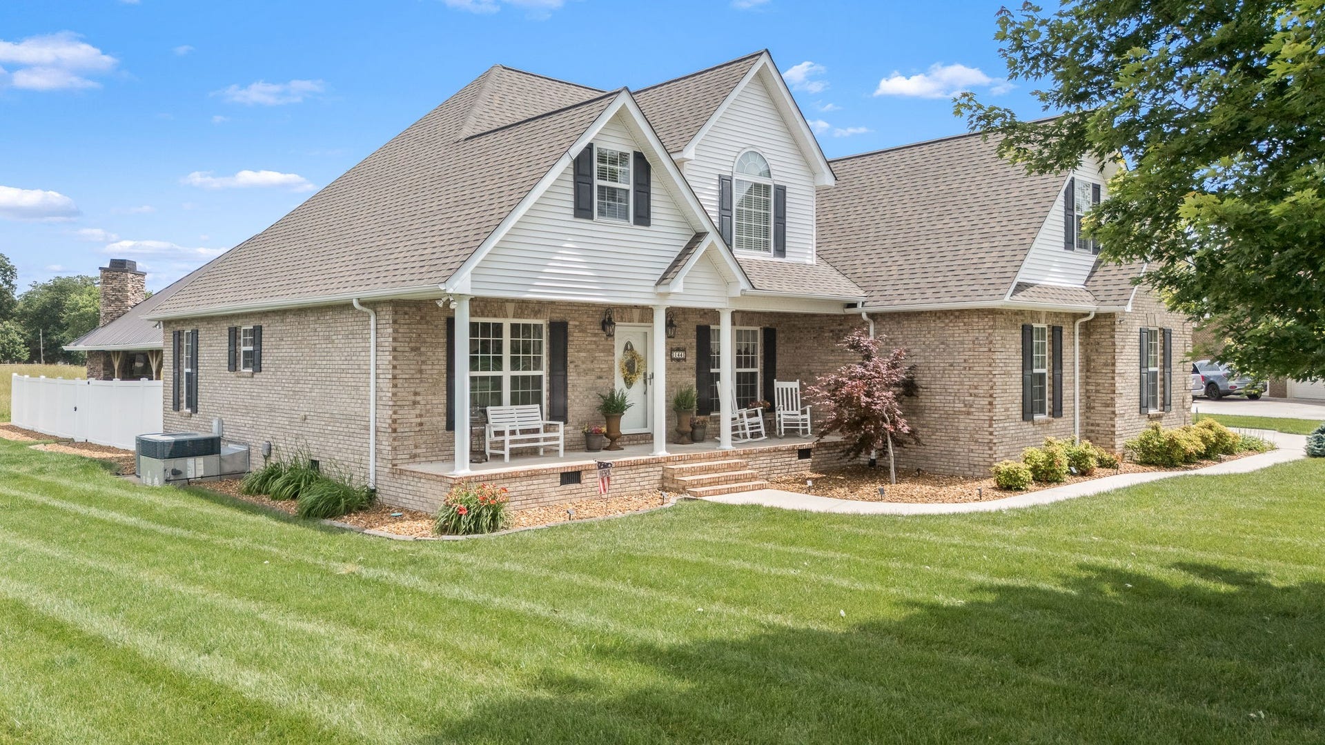 144 Richland Ct, Manchester, TN 37355 This immaculate residence boasts a beautifully landscaped yard, featuring a lush green lawn.