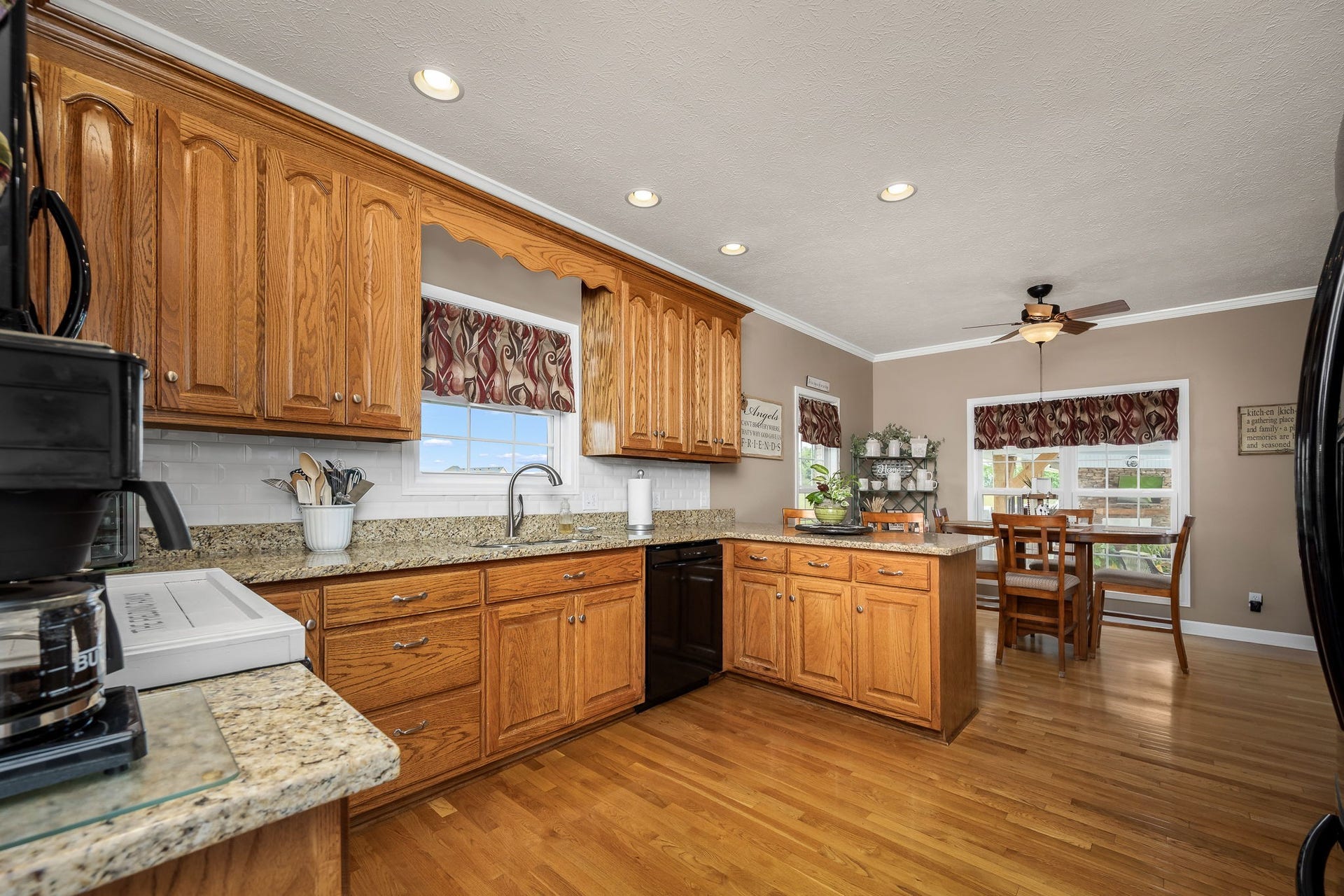 144 Richland Ct, Manchester, TN 37355 The gourmet kitchen boasts hardwood flooring, granite countertops, a peninsula island with bar seating, and a stylish tile backsplash.