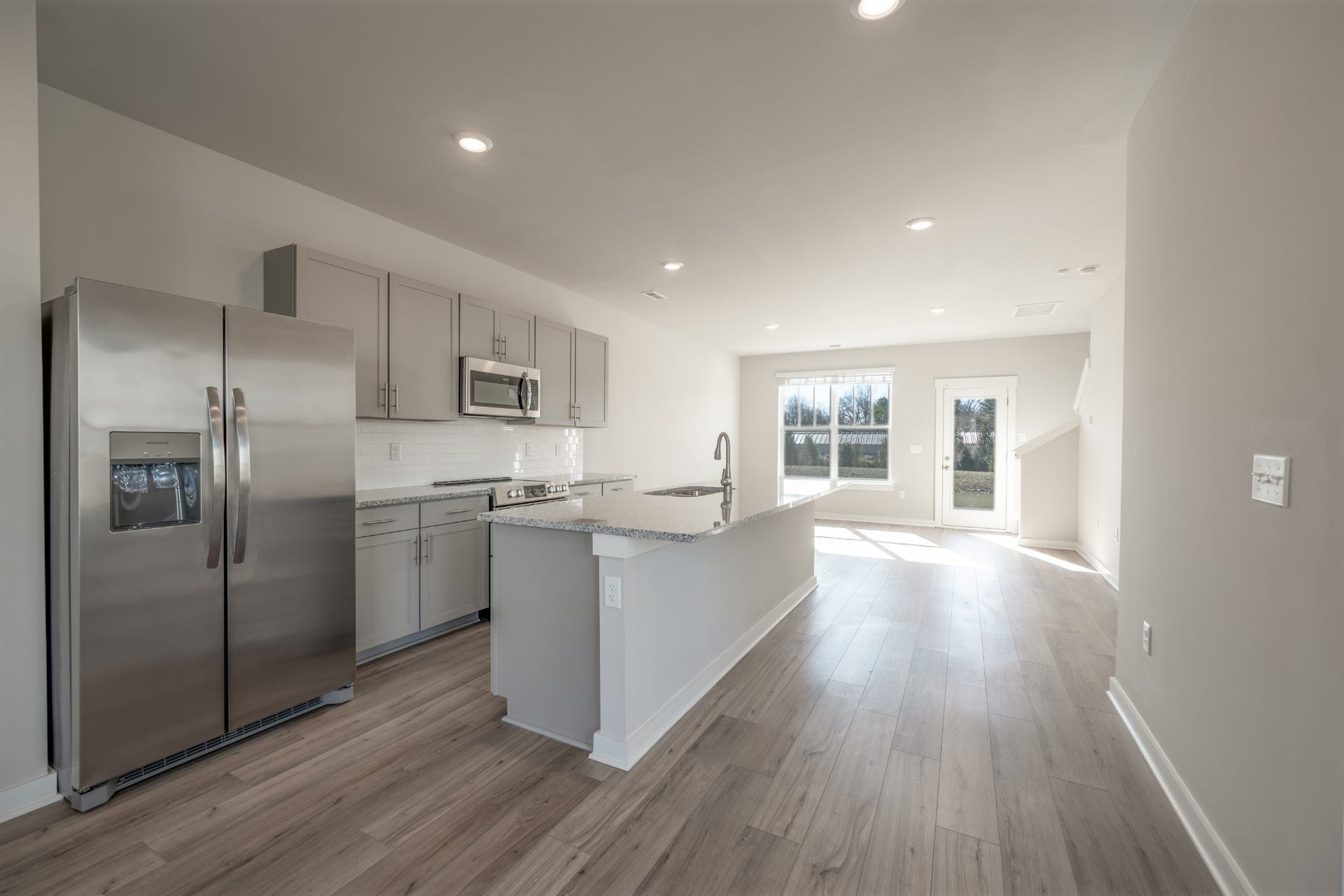 Granite counters and stainless appliances including refrigerator, range/oven, microwave, and dishwasher