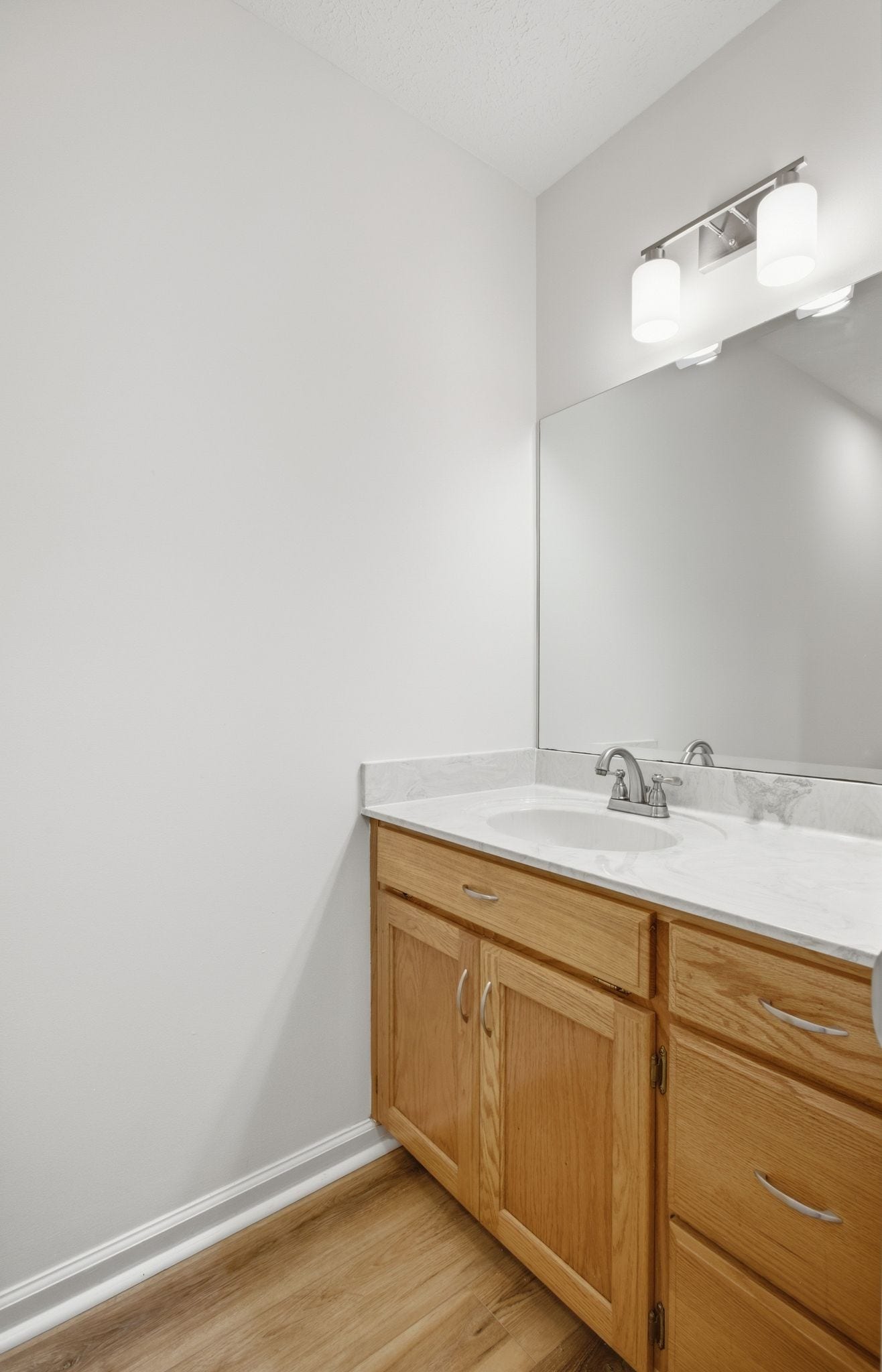 Half Bath ~ Main Floor: New flooring, lighting, faucet and cabinet hardware