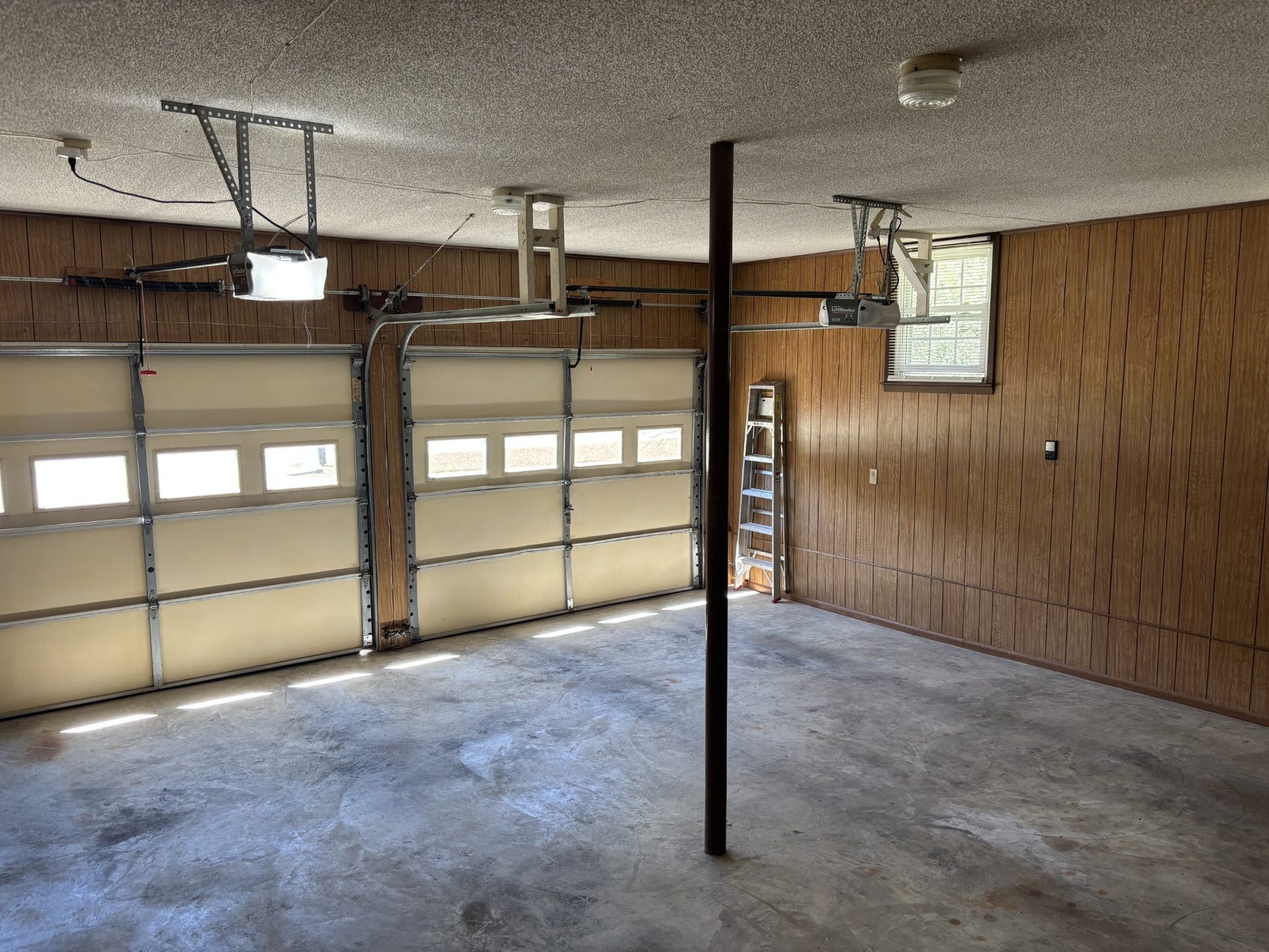 141 Doak Rd, Manchester, TN 37355 Two car garage with separate doors with openers. Workshop room is in the garage with top to bottom shelving and a pegboard wall.