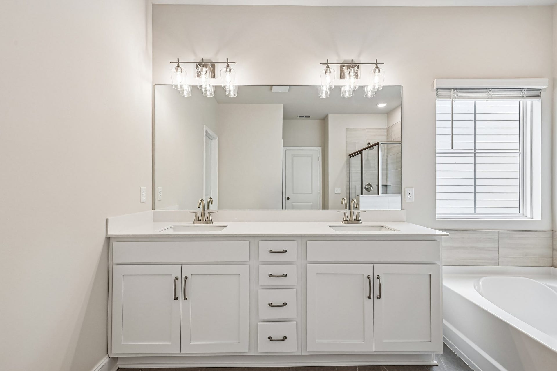 2705 Wilkinson Pike, #2, Murfreesboro, TN 37129 The primary bathroom is beautifully designed with tile flooring and dual sinks with quartz countertops, combining functionality with a sleek modern aesthetic for a spa like retreat.