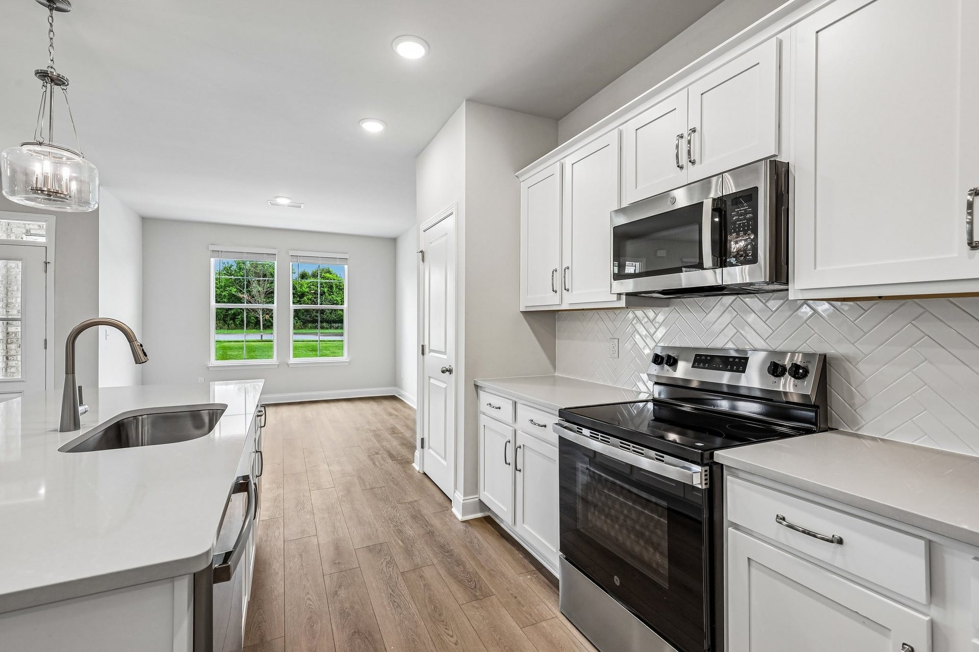 2705 Wilkinson Pike, #2, Murfreesboro, TN 37129 White cabinetry with soft close doors, a stylish herringbone backsplash, and stainless-steel appliances elevate the kitchen with both beauty and functionality.