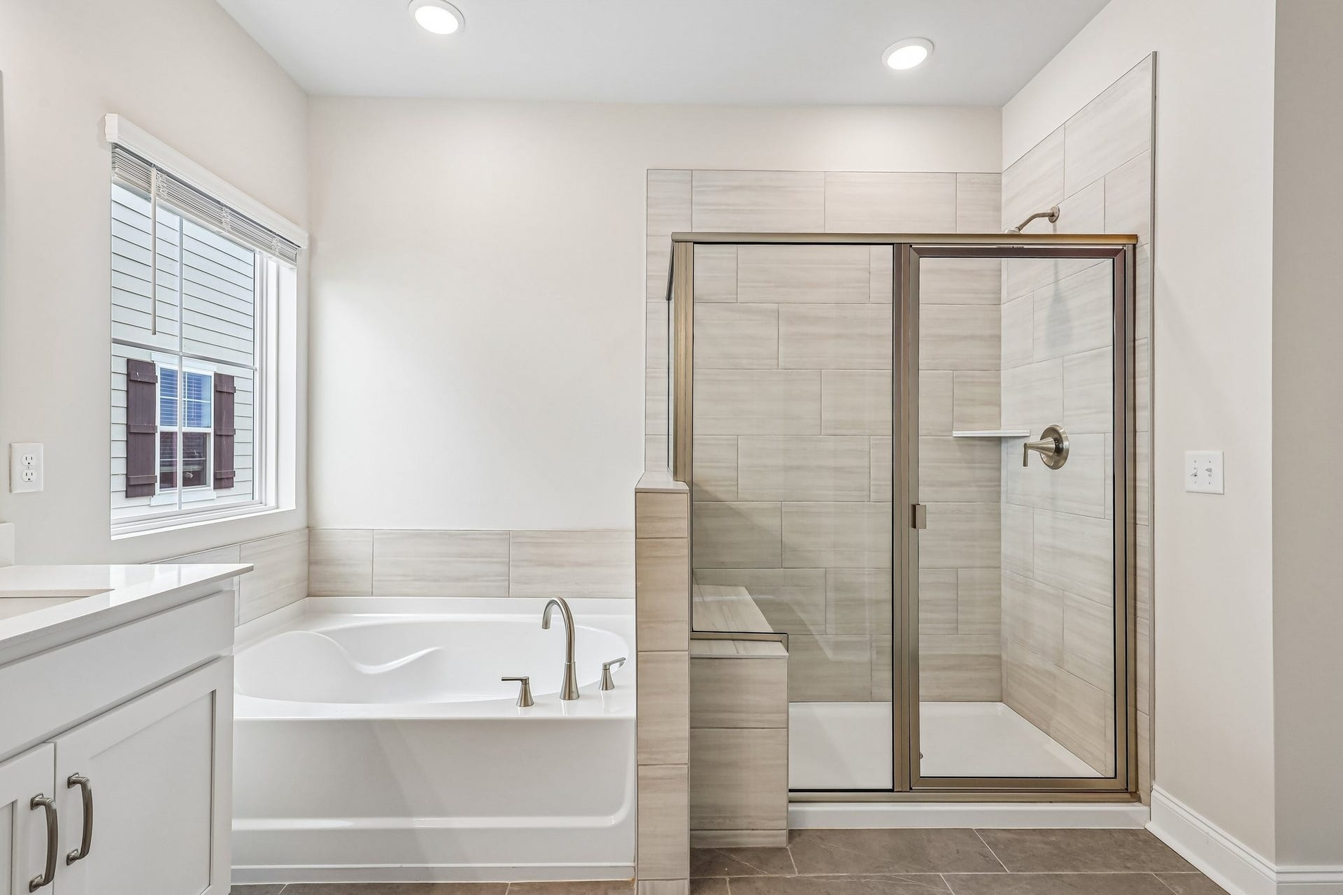 2705 Wilkinson Pike, #2, Murfreesboro, TN 37129 The primary bathroom is thoughtfully designed for both style and comfort. It includes a tiled shower with a built-in bench, perfect for relaxing or convenient daily use, alongside a soaking tub ideal for unwinding after a long day.