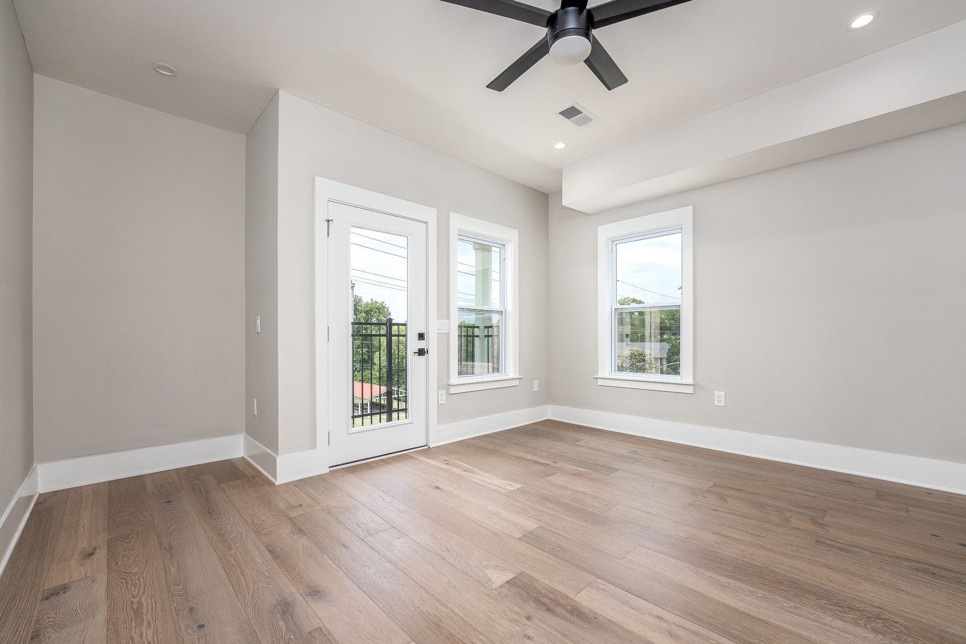 428 E Trinity Ln, #B, Nashville, TN 37207 Primary Bedroom with Balcony and Ensuite Bathroom featuring Italian Tile Surround Shower with Dual Quartz Vanities with lighted Mirrors and luxury accent lighting sconces.