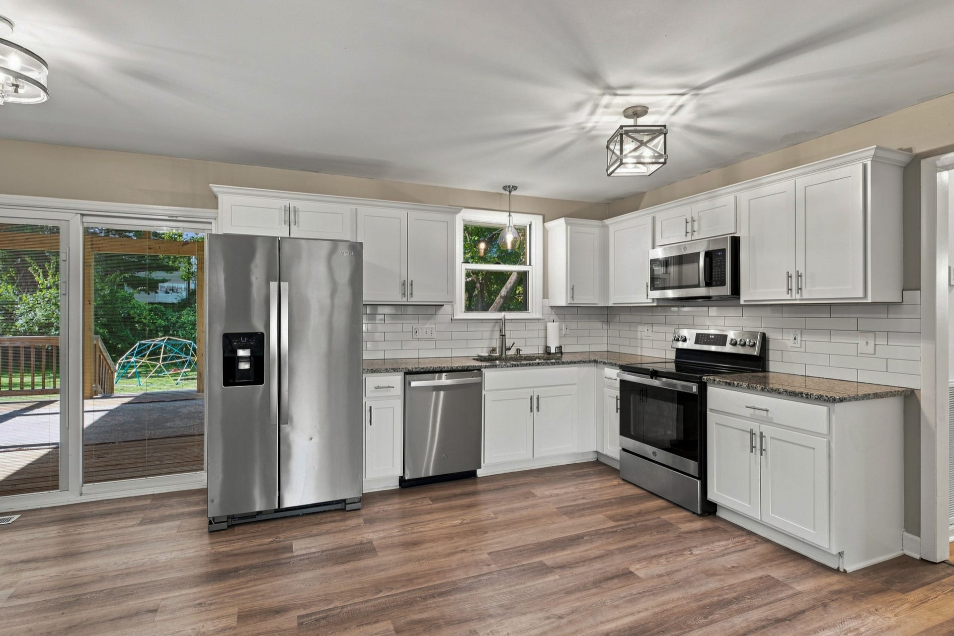 3312 Masonwood Dr, Nashville, TN 37207 The beautifully updated kitchen features white shaker cabinetry, stainless steel appliances, subway tile backsplash, generous counter space, and easy access to the deck for seamless indoor-outdoor living.