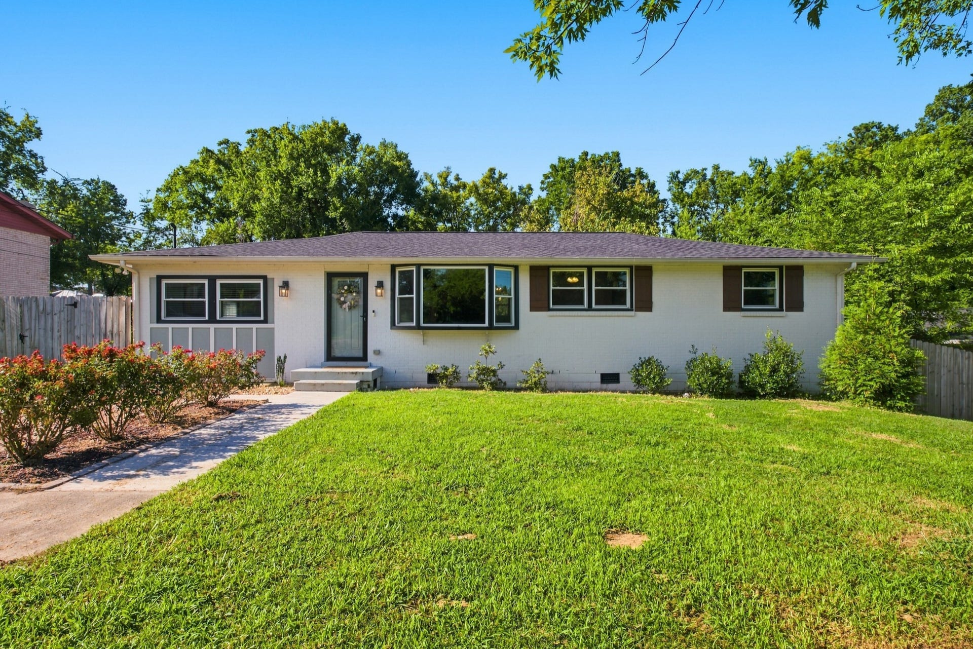 3312 Masonwood Dr, Nashville, TN 37207 Charming painted brick ranch with mature landscaping and a spacious front lawn.