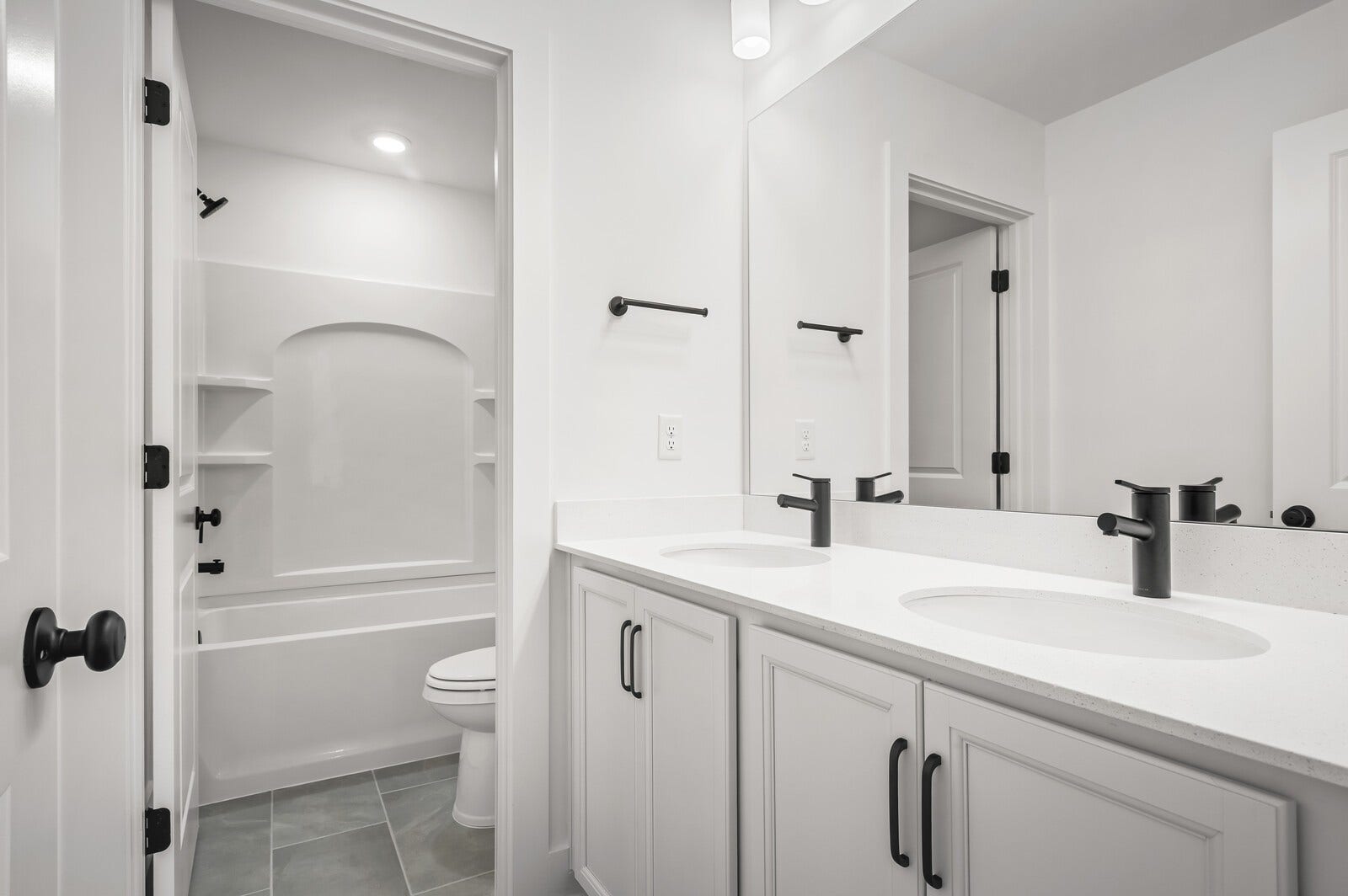 3529 Winterfell Drive, Murfreesboro, TN 37129 Secondary bathroom upstairs features a double vanity with white cabinetry and matte black fixtures/finishes, tiled flooring, and a separate room for the shower/commode.
