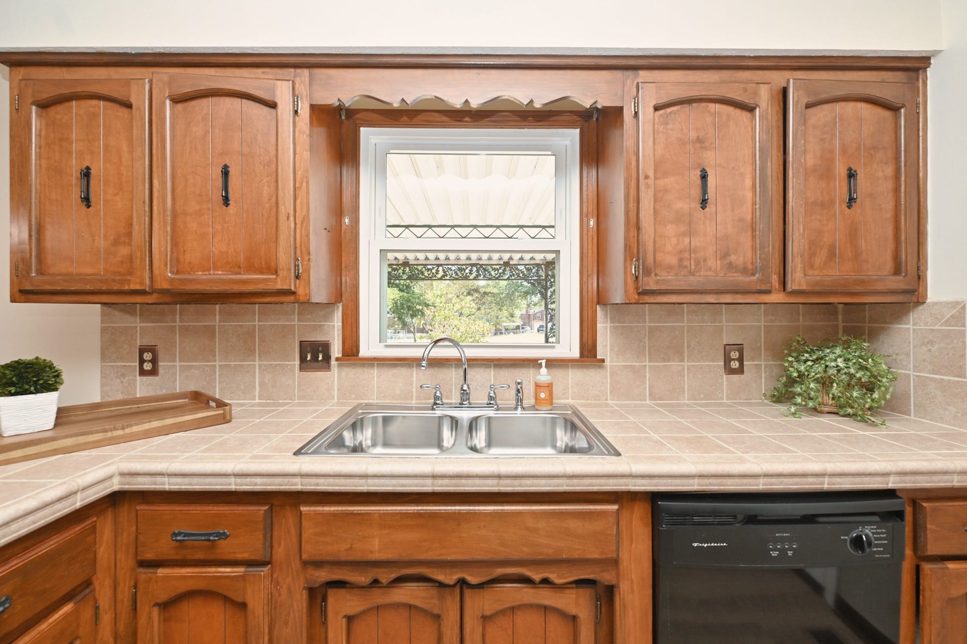 Kitchen sink window overlooks parklike backyard