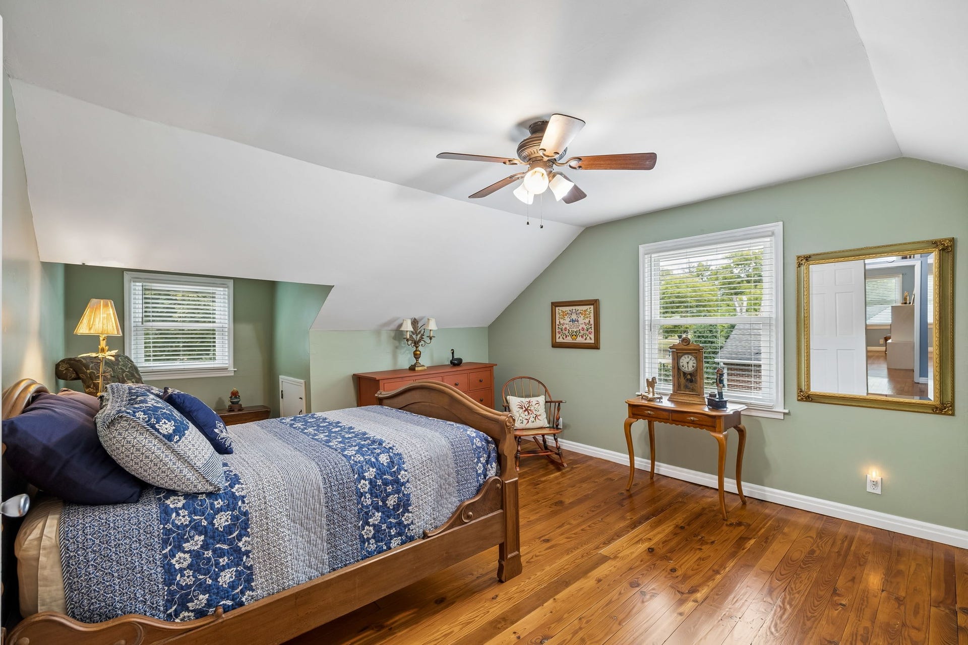 Upstairs, the home reveals even more room to spread out. This spacious bedroom is filled with natural light, beautiful hardwood floors, and a soft, calming palette that makes it feel like a true retreat.