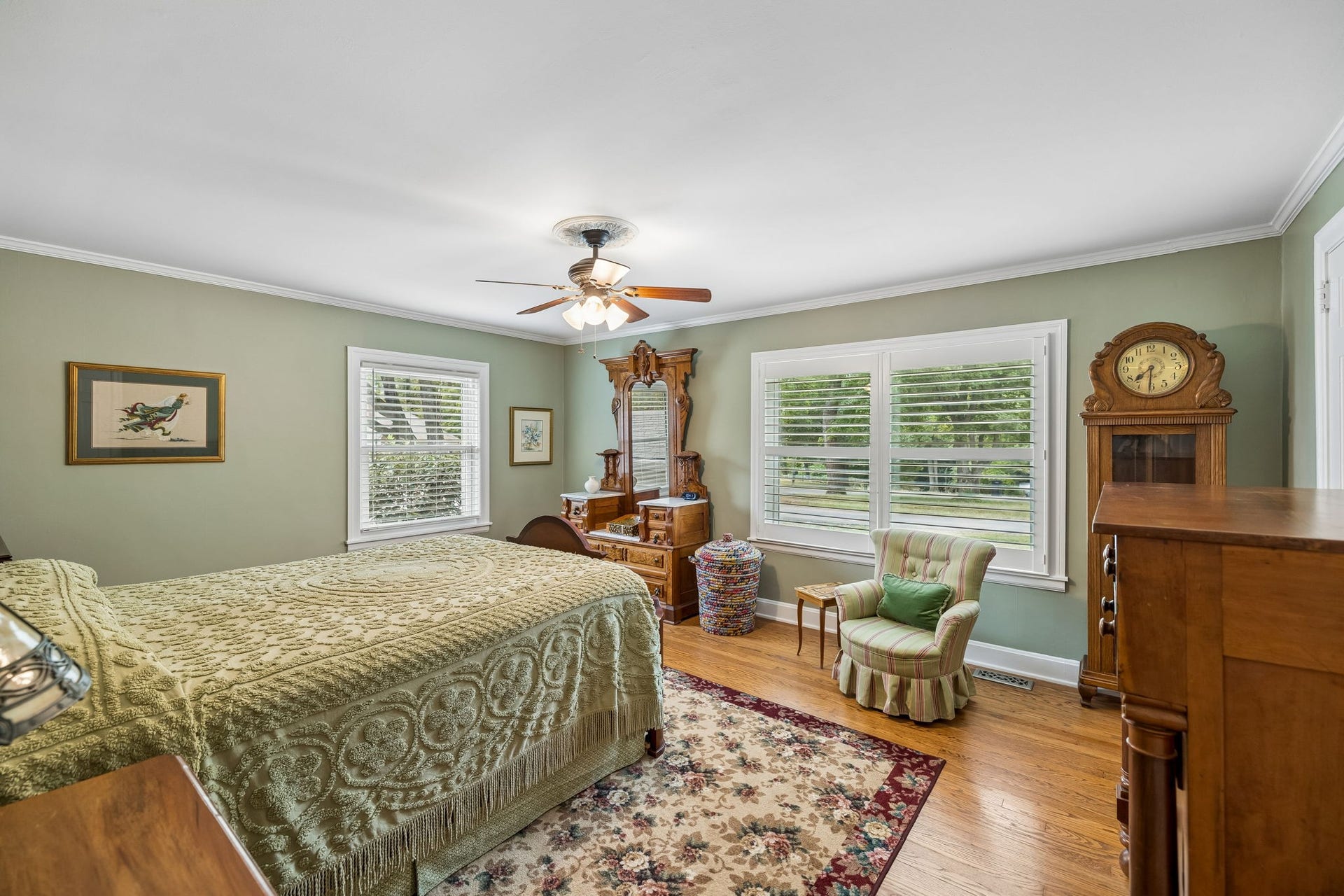 A bedroom that feels like it has been loved for generations. Soft green walls, beautiful hardwood floors, generous windows, and classic details create a peaceful retreat with room to slow down and settle in.