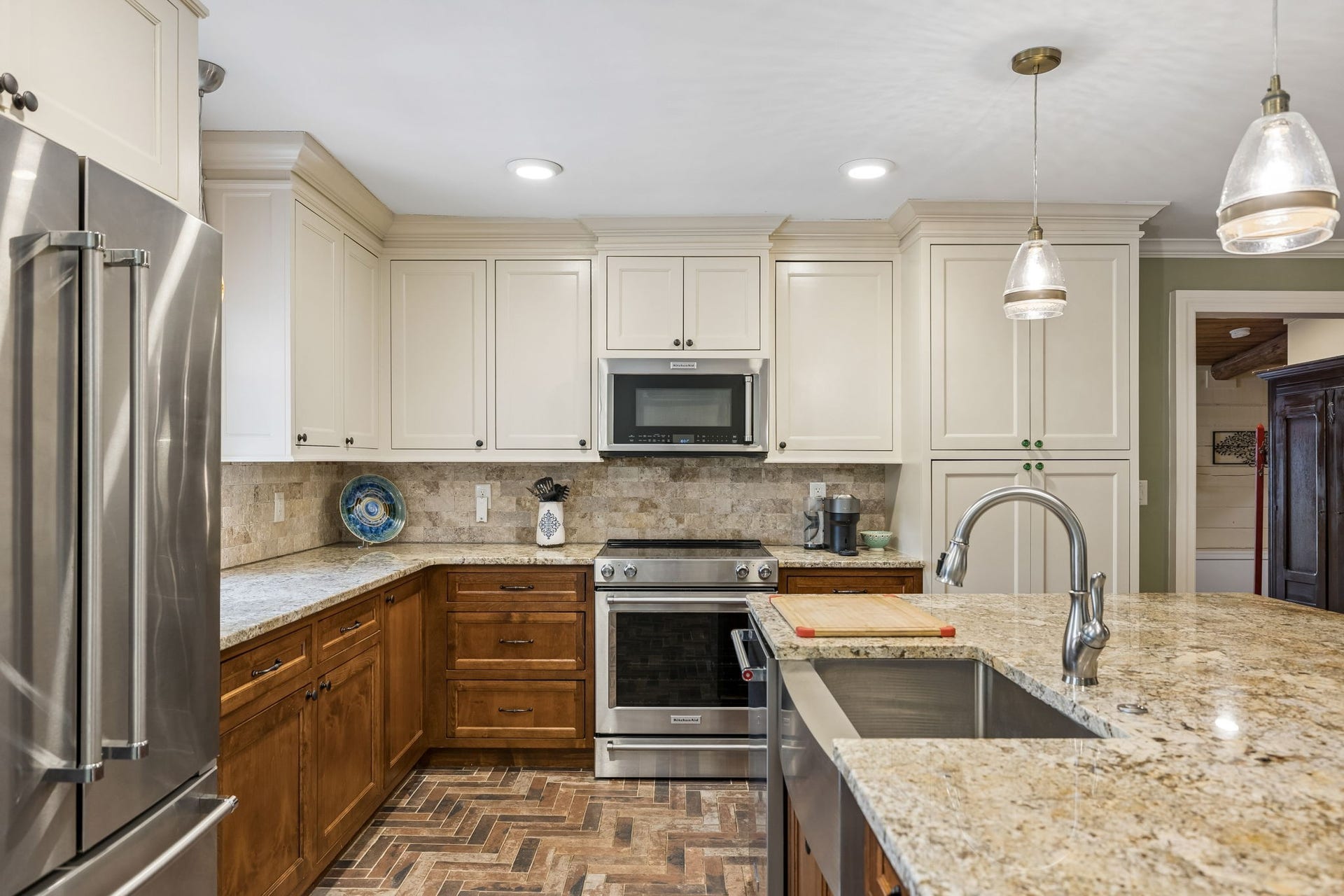 A kitchen that feels like the heart of the home. This space has been fully renovated with beautiful cabinetry, granite countertops, stainless appliances, and a generous island bringing together the character of the home.