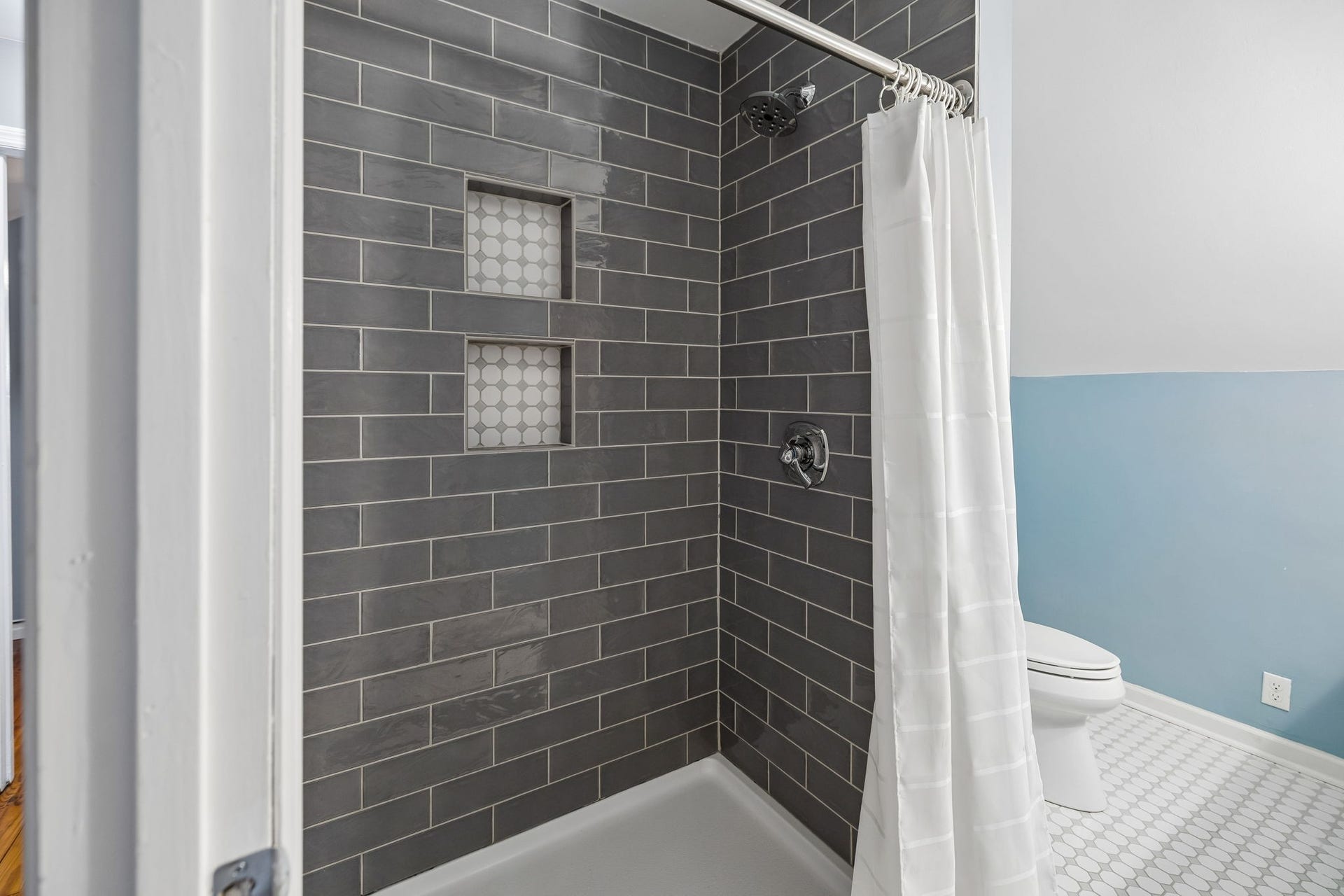 Classic tile, thoughtful details, and a timeless feel. The walk-in shower adds a beautiful finishing touch to this bright upstairs bath.