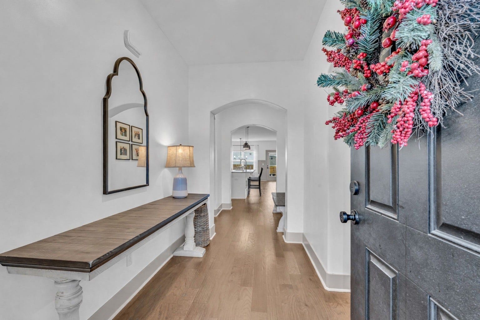 This entry welcomes you with arched openings and beautiful laminate wood flooring.