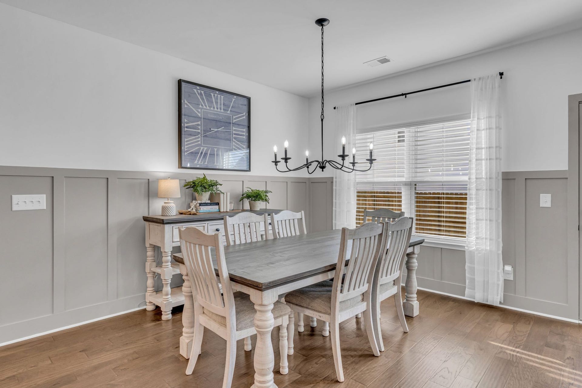 This dining area is lovely and is centered by a large black candelabra chandelier.