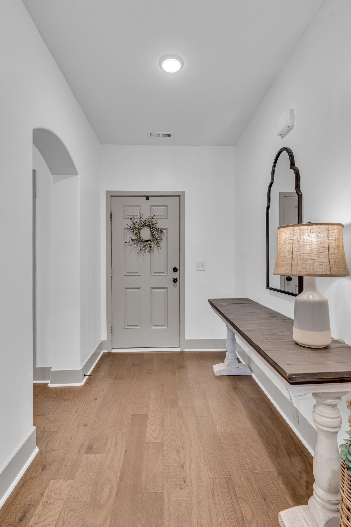 This entry welcomes you with arched openings and beautiful laminate wood flooring. The secondary bedrooms are off the front hallway.