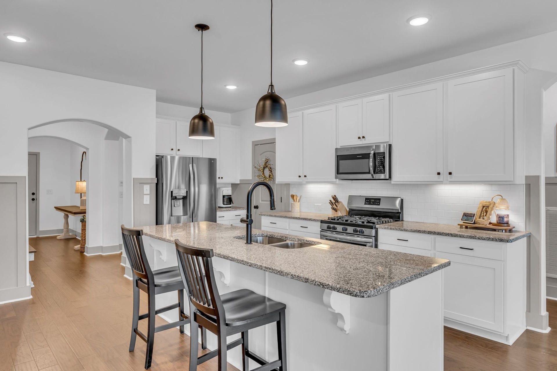 The kitchen features stainless appliances, black hardware and granite counter tops.