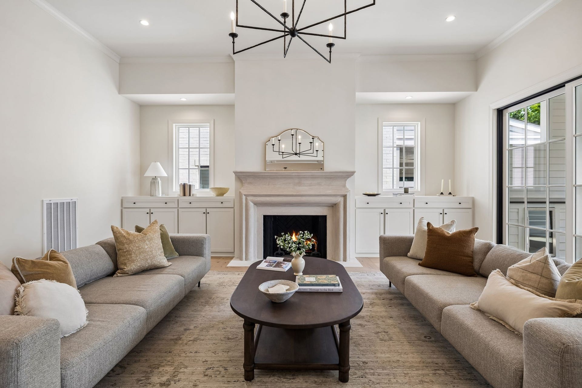 1133 Maplehurst Ln, Nashville, TN 37204 The fireplace creates an inviting focal point, complemented by symmetrical built-in cabinetry, tall windows, and sophisticated architectural details.