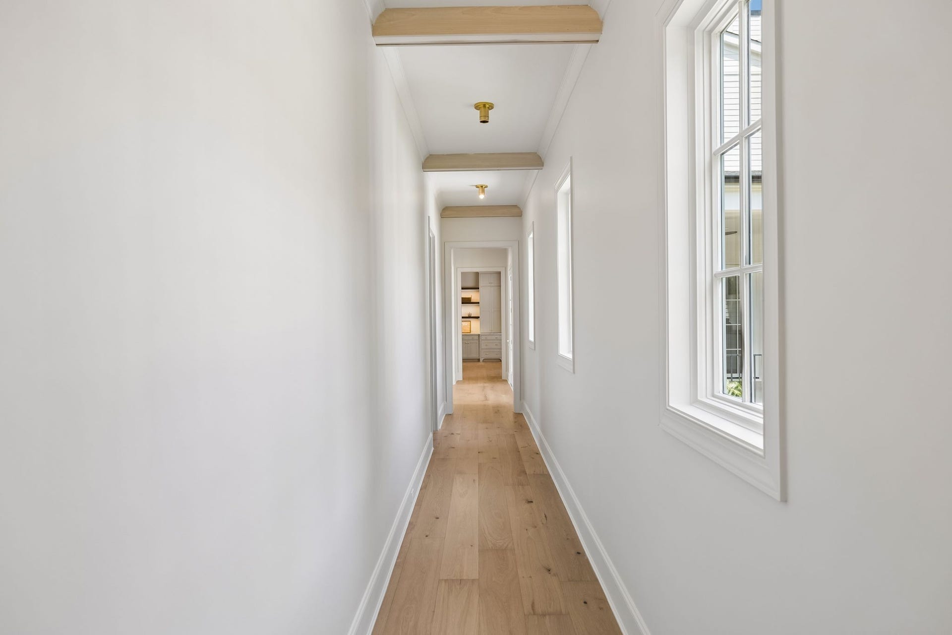 1133 Maplehurst Ln, Nashville, TN 37204 Light-filled hallway leads to the private primary wing, creating separation from the main living areas while maintaining an open, connected flow. (looking back from primary)