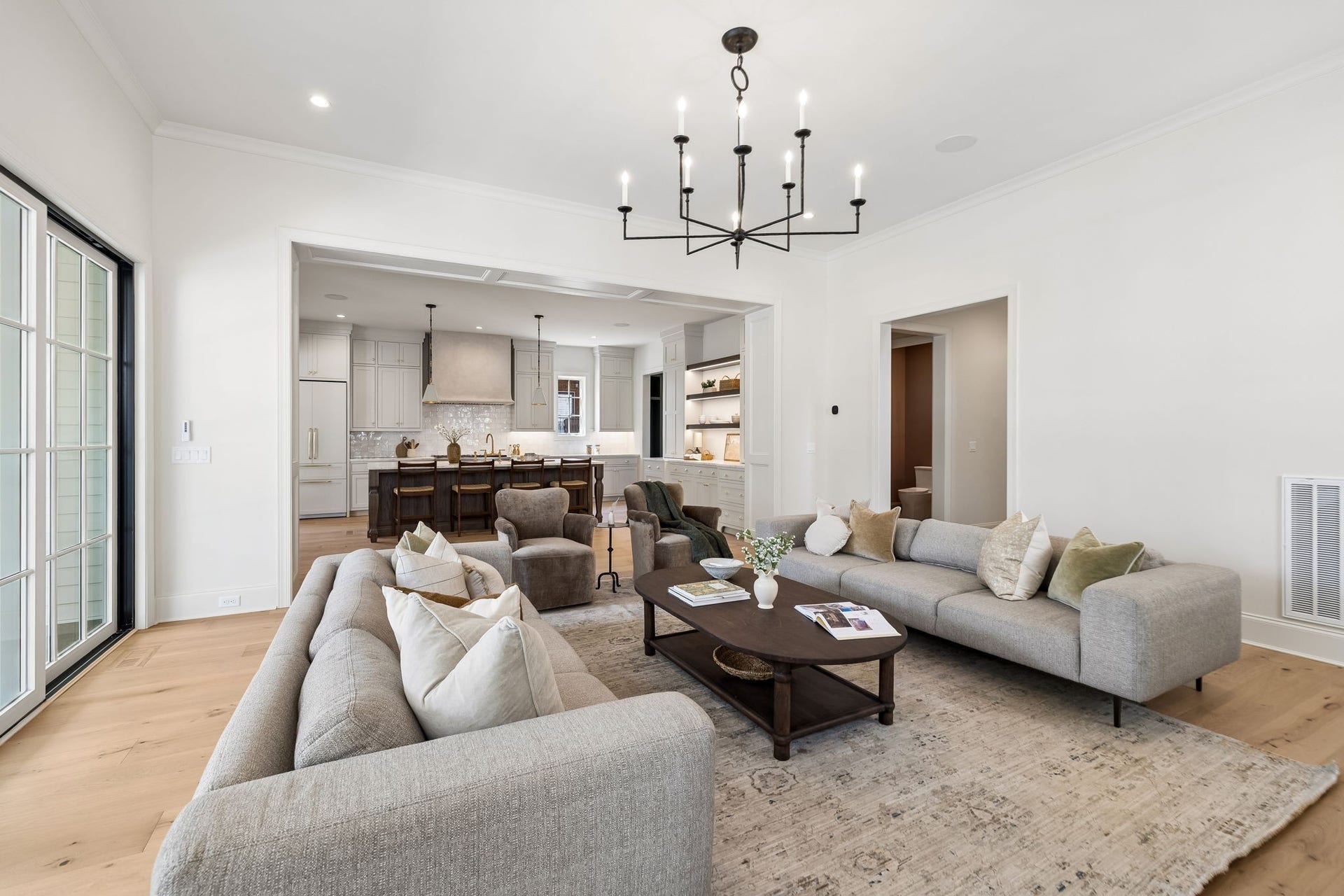 1133 Maplehurst Ln, Nashville, TN 37204 A wide architectural opening connects the great room and kitchen while maintaining definition between the spaces. Thoughtful millwork and abundant natural light elevate the open-concept design.
