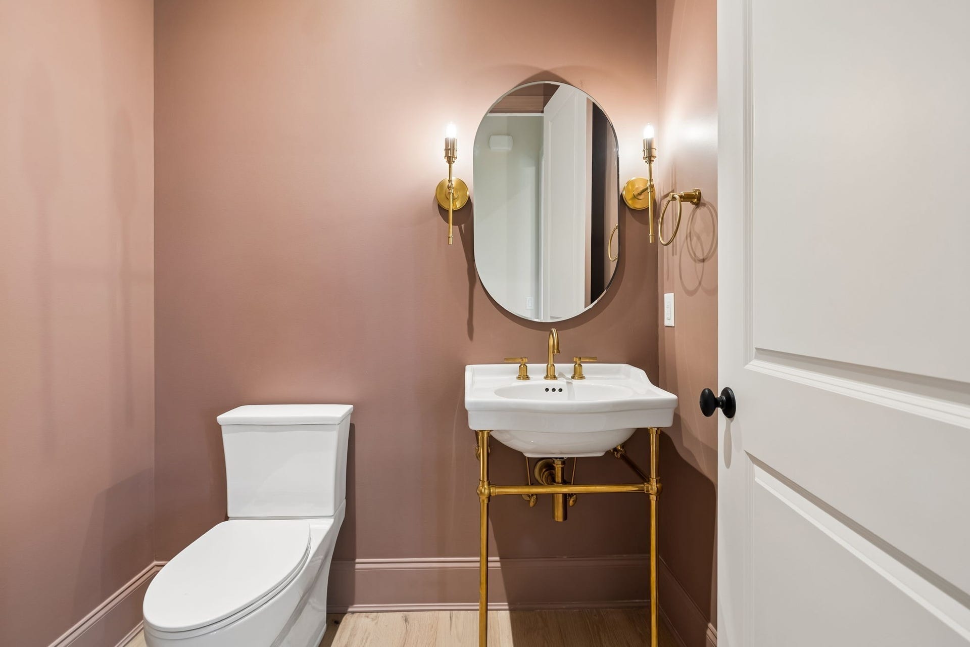 1133 Maplehurst Ln, Nashville, TN 37204 Charming powder room makes a statement with rich color, elegant brass fixtures, designer sconces, and a classic console sinkanother example of the thoughtful details found throughout the home