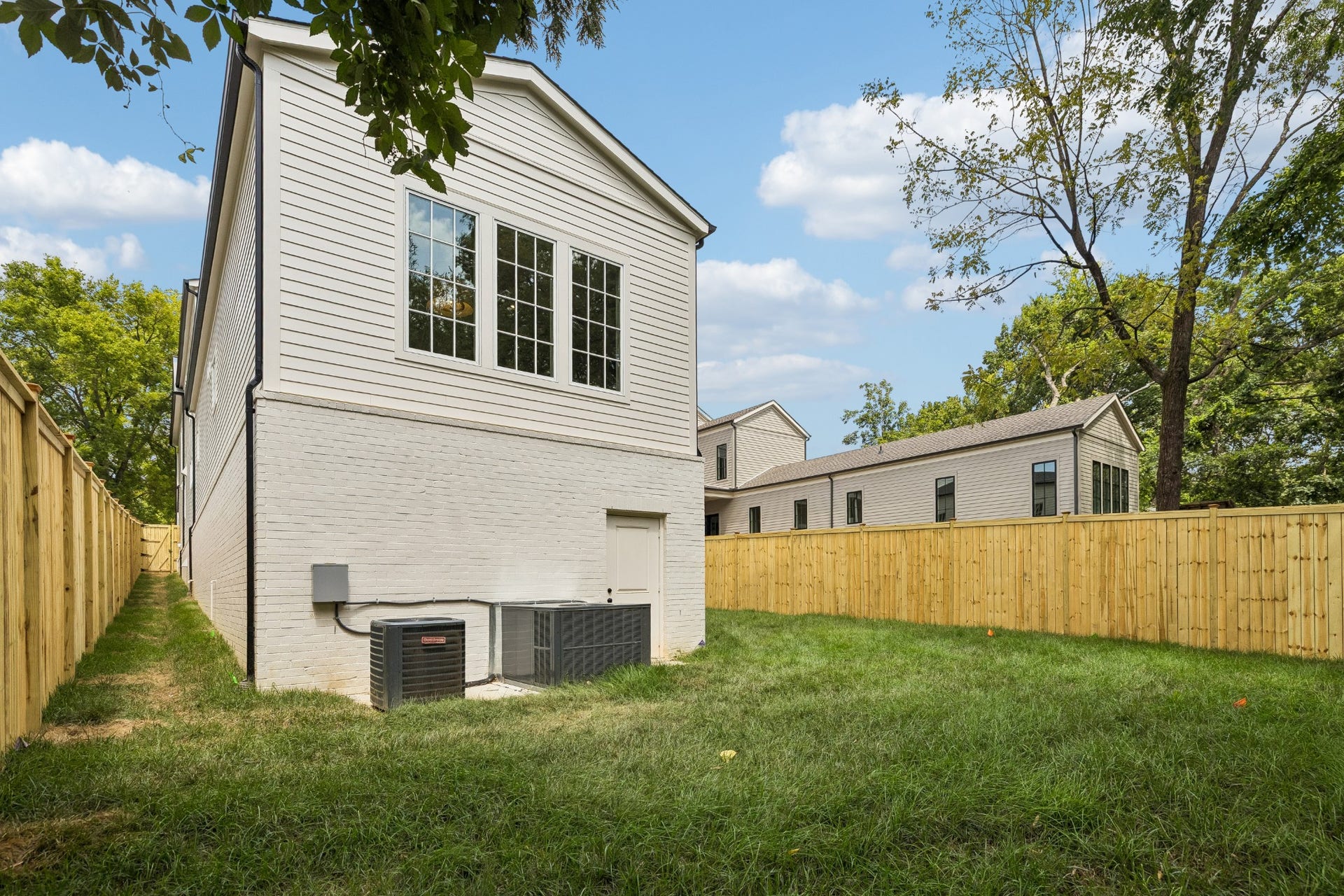 1133 Maplehurst Ln, Nashville, TN 37204 A tall privacy fence surrounds the backyard, creating a private outdoor retreat while mature trees beyond the property add a beautiful natural backdrop.