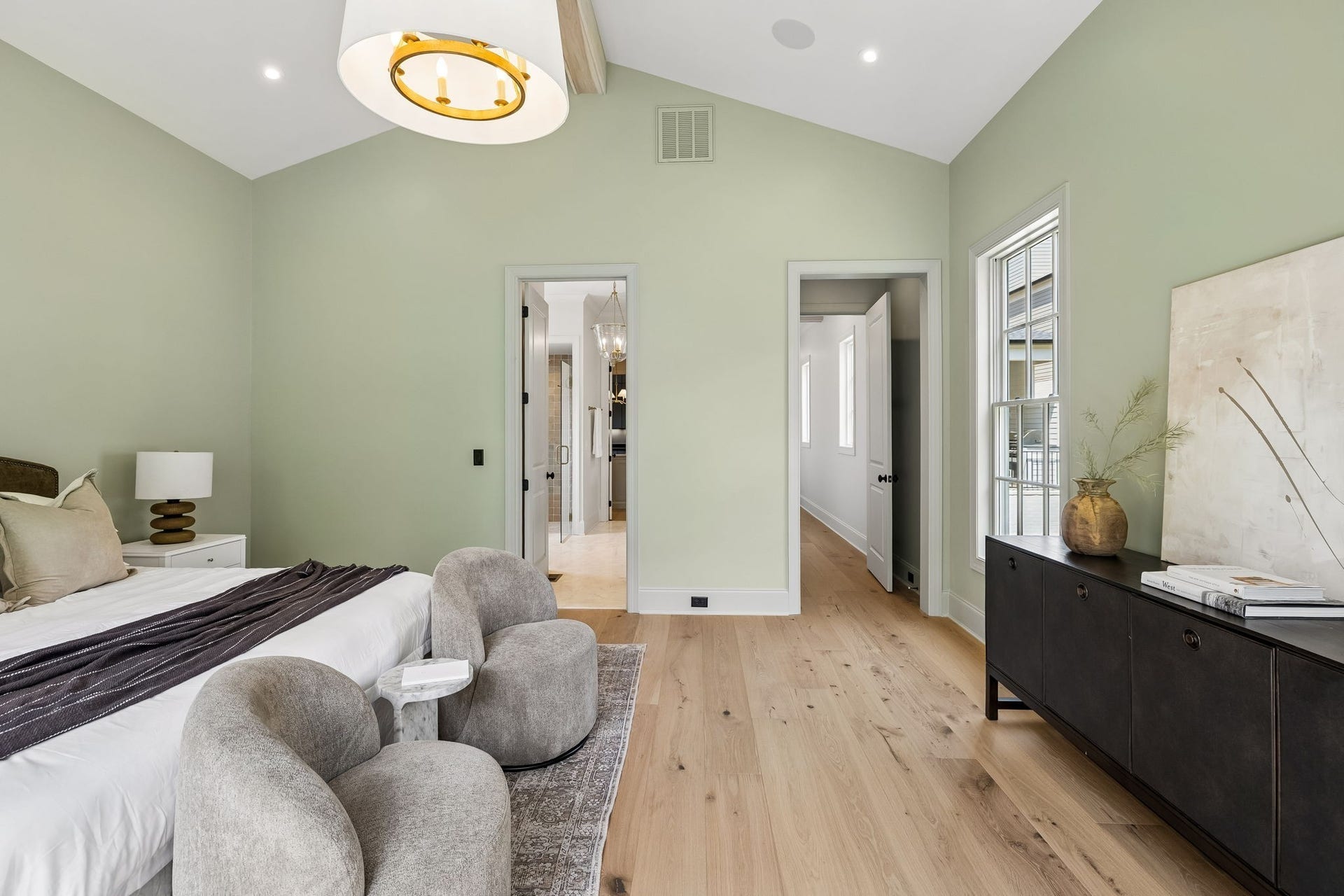 1133 Maplehurst Ln, Nashville, TN 37204 Spacious primary suite features soaring vaulted ceilings, hardwood floors, designer lighting, and a soft, sophisticated color palette.
