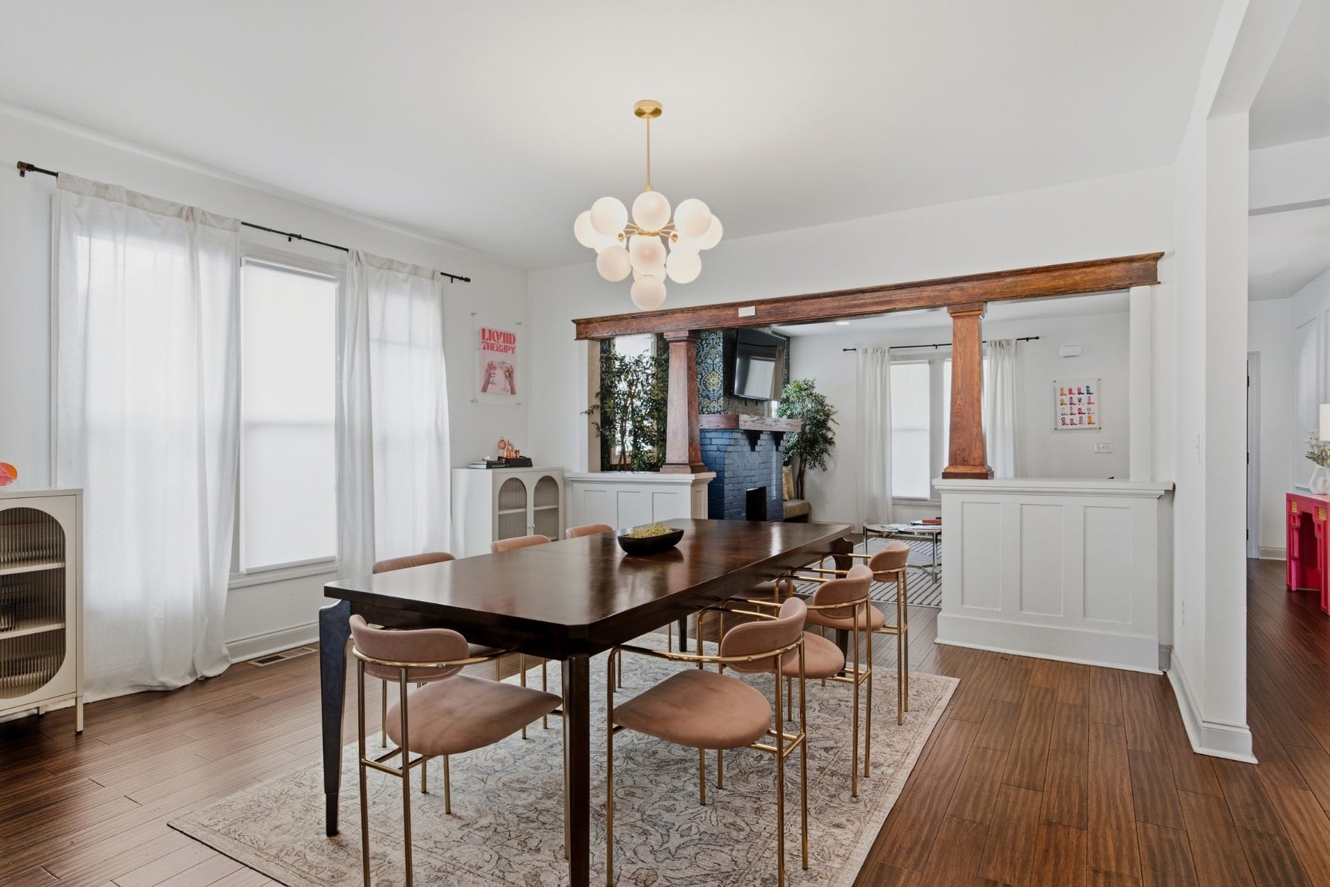 The inviting dining room gets a designer touch from a striking statement fixture overhead.