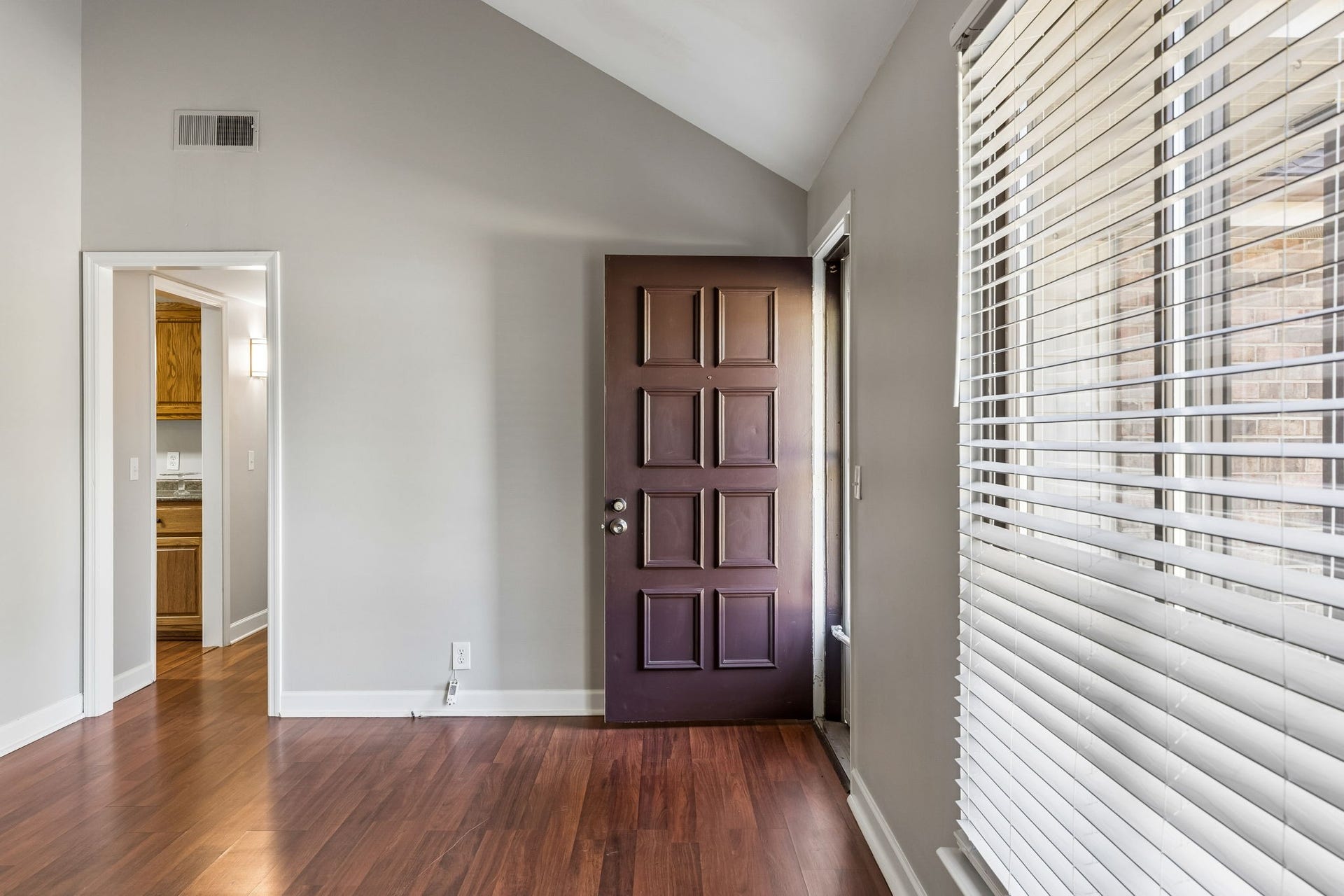 The great room with vaulted ceiling, wood burning fireplace & ceiling fan welcome all your guests!