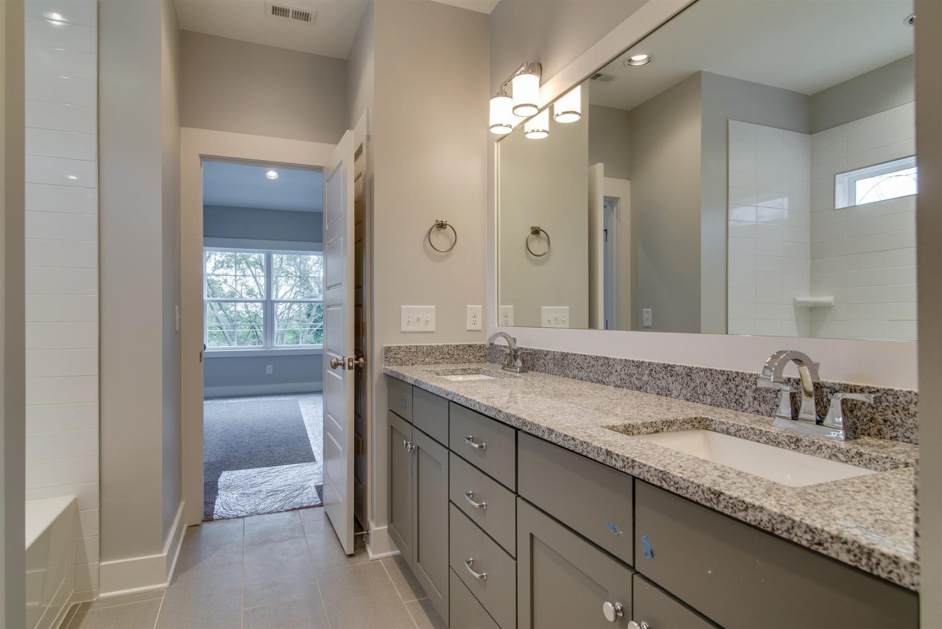 1711 10th Avenue S, Nashville, TN 37203 Second bathroom with double vanities. granite counter tops, designer tile flooring.