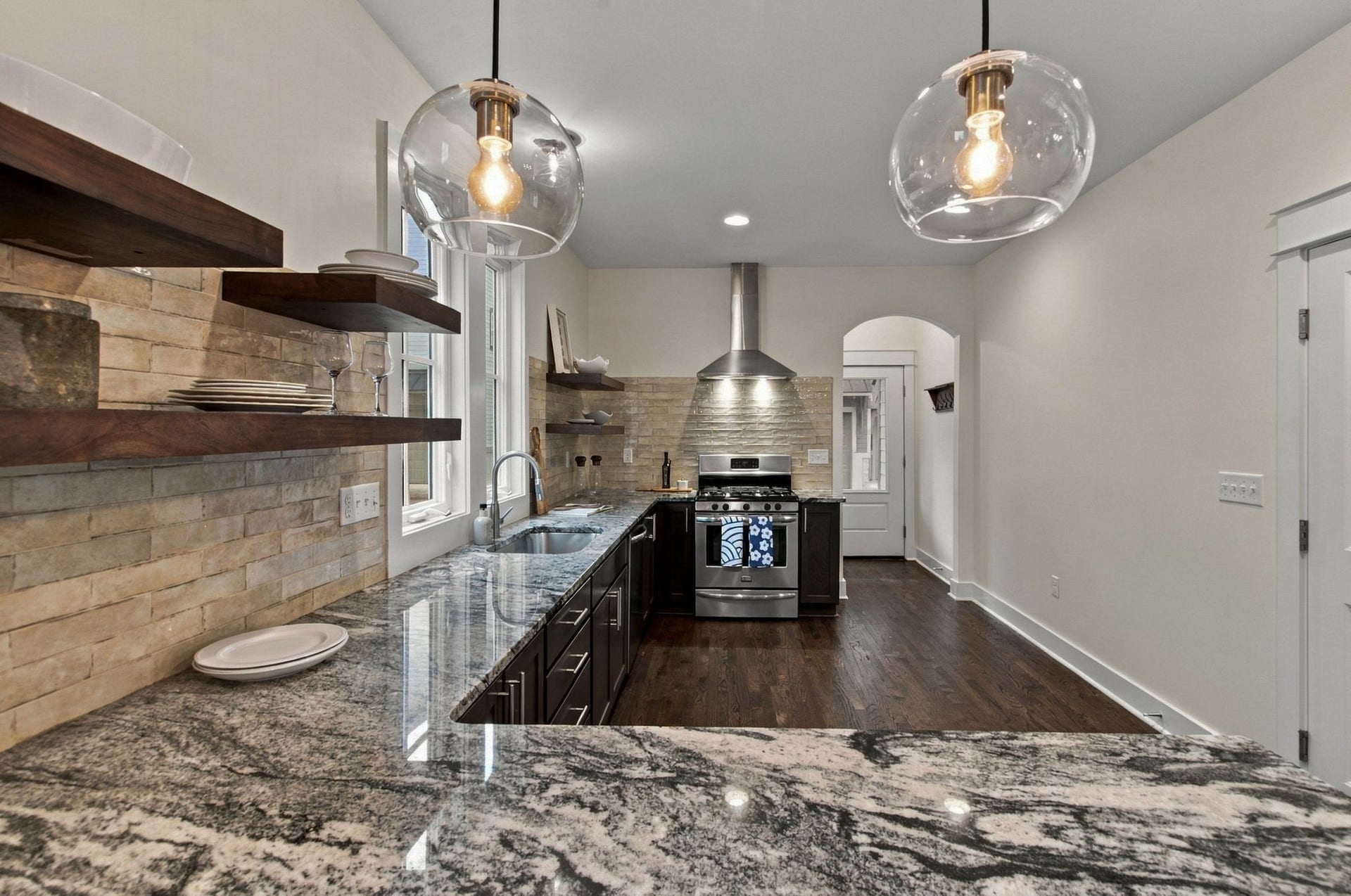 notice the arched opening separating the kitchen from the entry. There is a walk-in pantry off the entry behind the range.