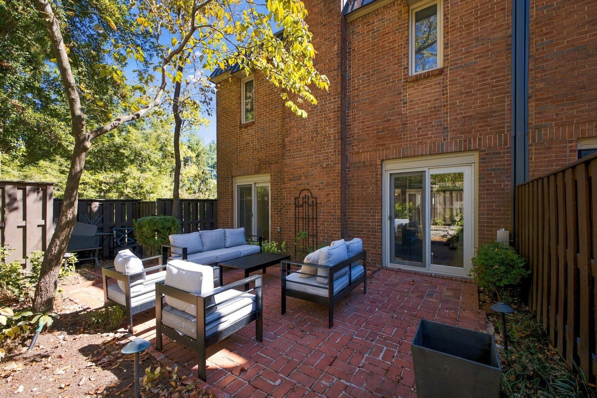 Secluded brick patio surrounded by mature landscaping