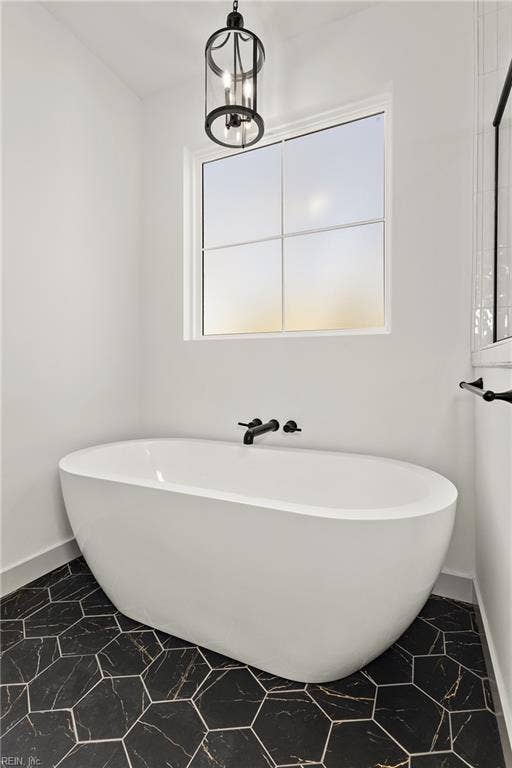 1st Floor Owner's Suite full bath includes custom soft close cabinets and drawers, double bowl vanity, ceramic tile flooring, stand alone soaking tub, step in shower with tile surround, and water closet.