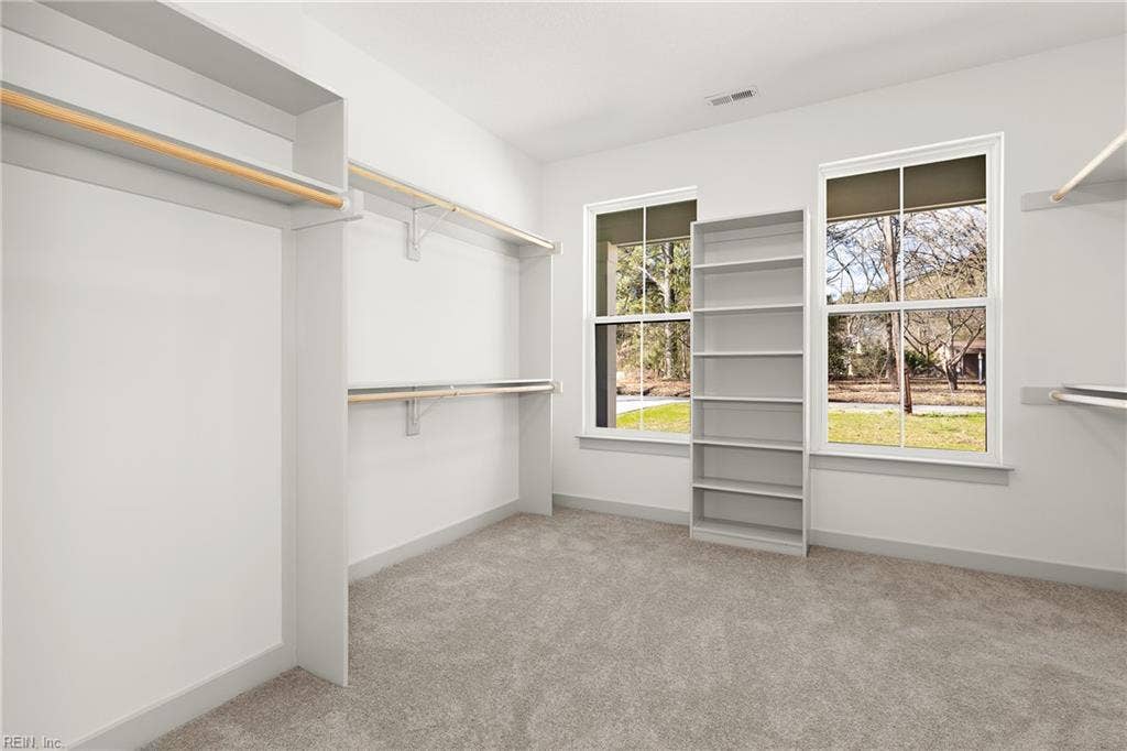 1st Floor Owner's Suite offers a large walk in closet with wood shelving.