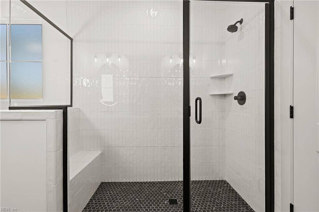 1st Floor Owner's Suite full bath includes custom soft close cabinets and drawers, double bowl vanity, ceramic tile flooring, stand alone soaking tub, step in shower with tile surround, and water closet.