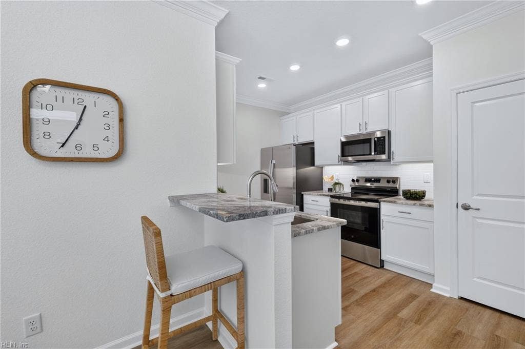 Upgraded kitchen with with soft close cabinets, subway tile backsplash, under cabinet lighting, granite counters and full SS appliance package to include fridge. Plus a pantry and breakfast bar