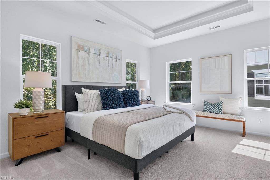 Primary bedroom flooded with natural light, a decorative ceiling,  walk-in closet and attached primary bathroom