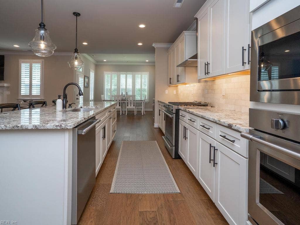 The gourmet kitchen is a chef's dream, boasting a huge island, upgraded painted cabinetry, a custom  backsplash