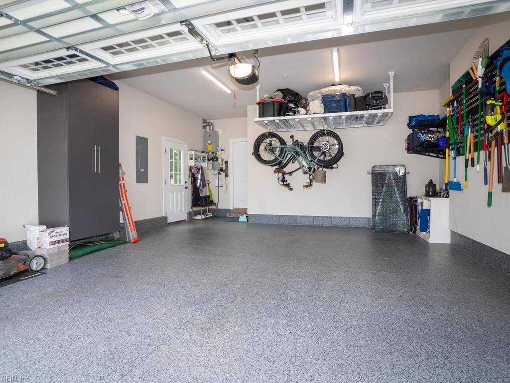 Rounding out the home’s exceptional amenities is a large two-car garage designed with both maximum utility and sleek organization in mind. The pristine, professionally sealed floor provides a durable, easy-to-clean surface . Overhead, a heavy-duty drop-down storage system
