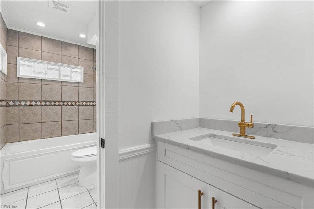 New bathroom vanity with quartz counters and gold hardware in the primary bedroom wash area.