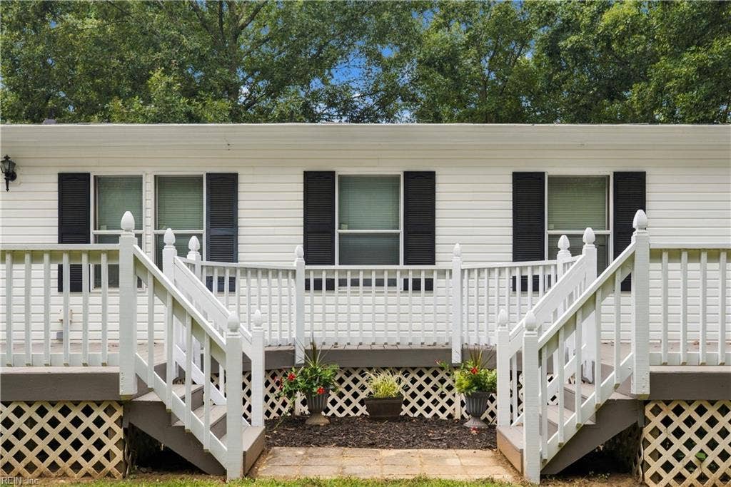 Back side of the home  with large back deck, access from either the family room or mud/laundry room.