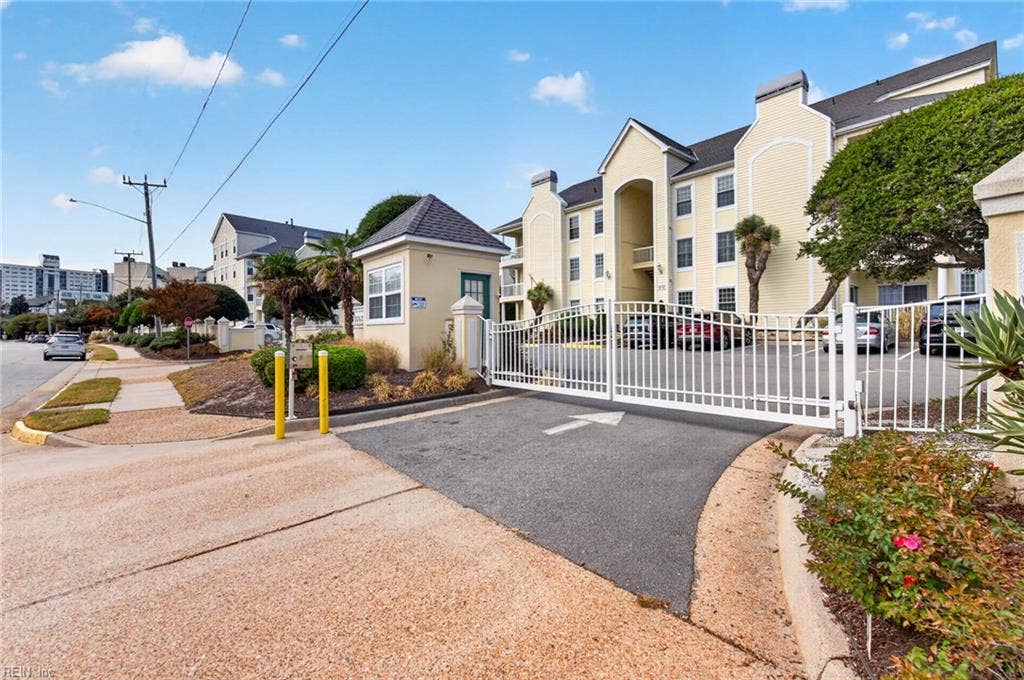 Gated entry to Lesner Pointe condominiums on Silver Sands Circle in Chic's Beach, Virginia Beach, with gatehouse, call box, and gate. Parking lot sits inside the gate. First-floor Unit 103 is in the community. 23451.