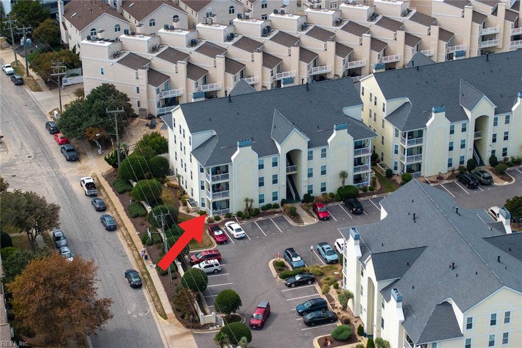 Aerial view marking the first-floor condo in the Lesner Pointe building, with the community parking lot beside it and the street nearby. One reserved parking space plus open unreserved spaces. Chic's Beach, Virginia Beach.