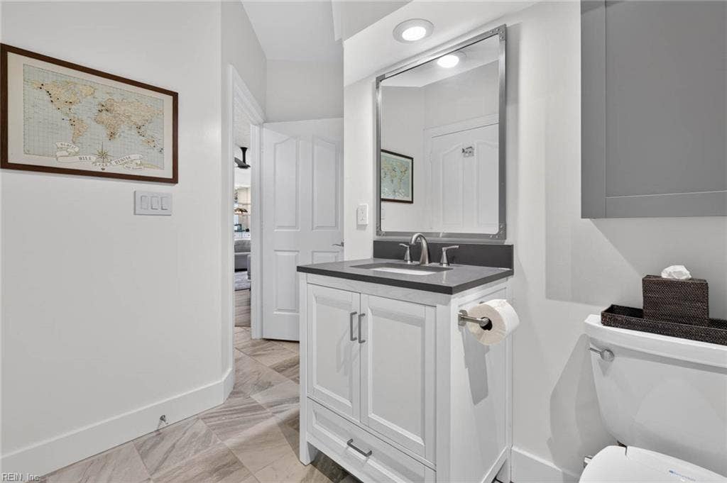 Hall bathroom with white vanity, framed mirror, recessed lighting, wall cabinet, and tile floor in this 3 bedroom, 2 bath first-floor condo at Lesner Pointe, Chic's Beach, Virginia Beach. 1,555 sq ft. 23451.