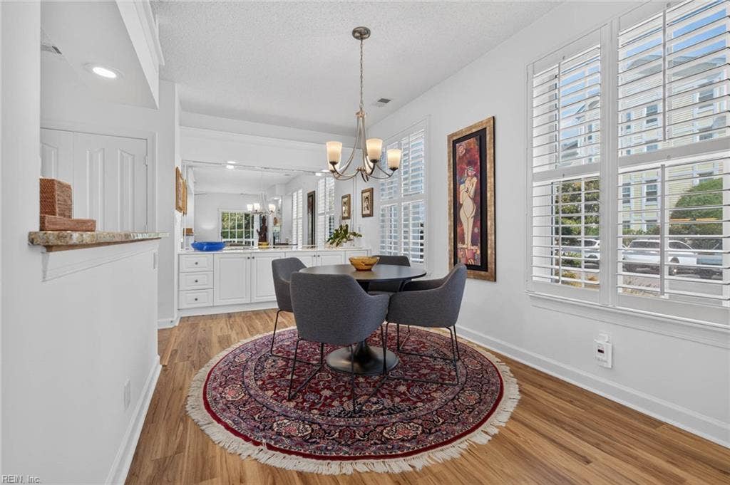 Dining area with built-in cabinets and countertop, mirrored wall, chandelier, and plantation shutters. Added storage and serving space in this Lesner Pointe first-floor condo, Chic's Beach, Virginia Beach. 23451.