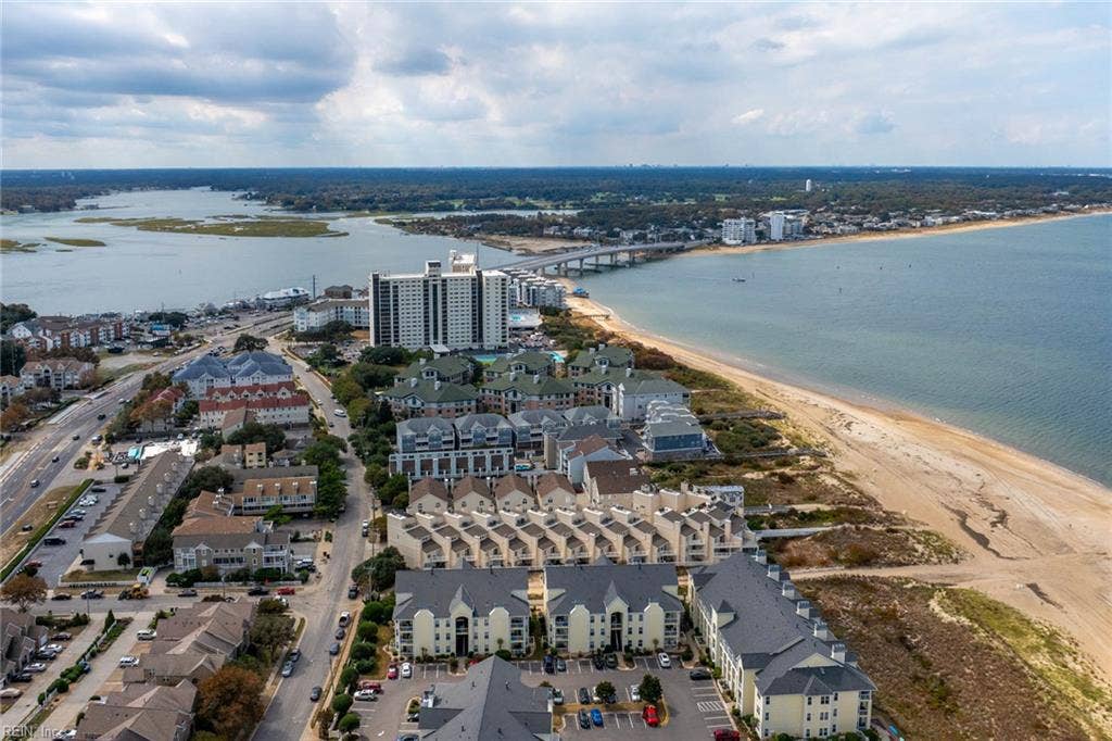 Aerial view of Lesner Pointe condominium buildings along the Chesapeake Bay beach in Chic's Beach, Virginia Beach, with Lynnhaven Inlet and Lesner Bridge nearby. Community sits in the 23451 ZIP code with beach access beside the pool.